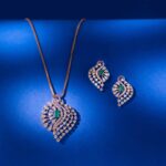Emerald Glow diamond pendent set with emerald center stone and leaf inspired diamond design in 18k gold with matching earrings