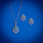 Diamond pendent set with hexagonal design and green center stone with matching earrings in 14k gold