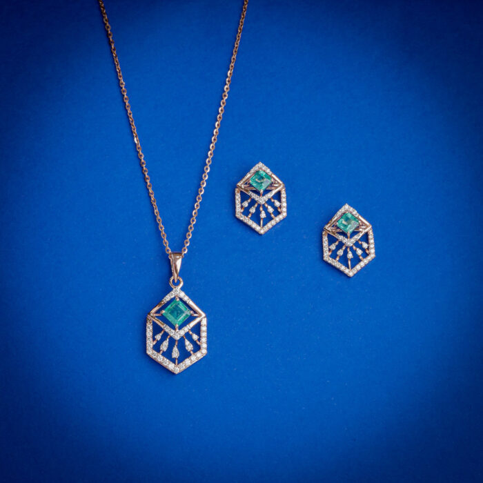 Diamond pendent set with hexagonal design and green center stone with matching earrings in 14k gold