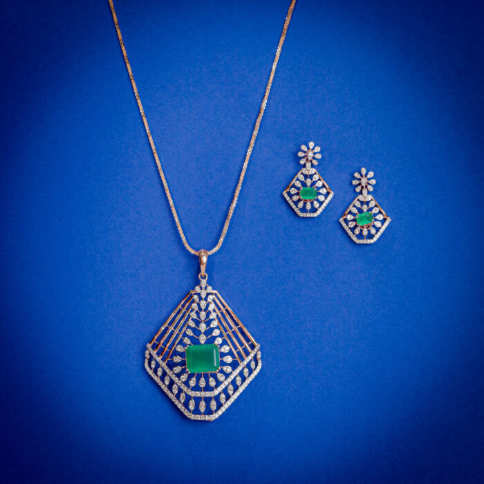 Diamond pendent set with geometric open frame design and emerald green center stone with matching earrings in 14k gold