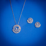 Diamond pendent set with spiral swirl design and leaf diamond motifs with matching earrings in 14k gold