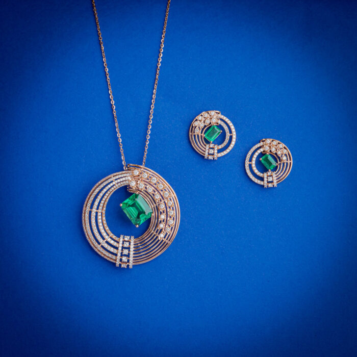 Diamond pendent set with emerald cut green stone and matching earrings in 18k gold