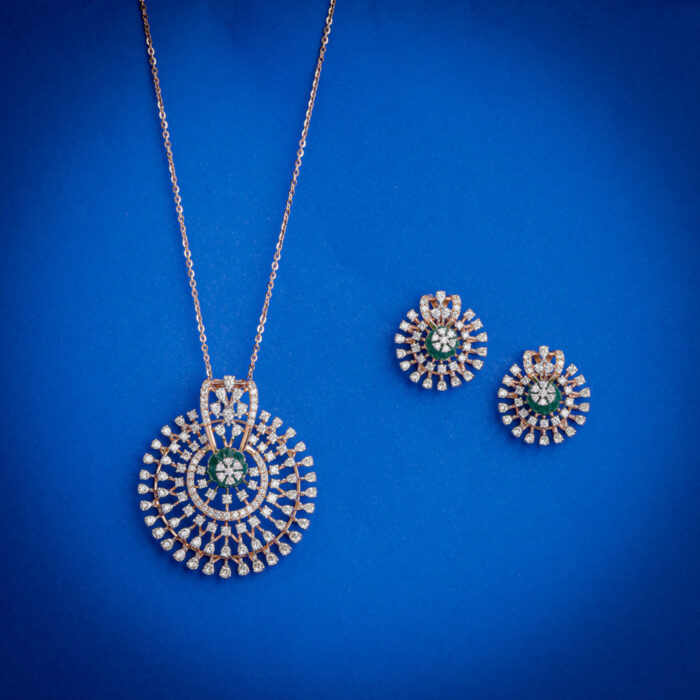 Diamond pendent set with concentric circular design and green center stone with matching earrings in 18k gold