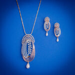 Diamond pendent set with elongated oval design, leaf diamond detailing and pearl drops with matching earrings in 14k gold