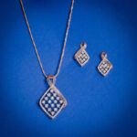 Diamond pendent set with twisted frame design and square diamond cluster with matching earrings in 14k gold