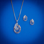 Elegant diamond pendent set with layered circular design and matching earrings in 18k gold