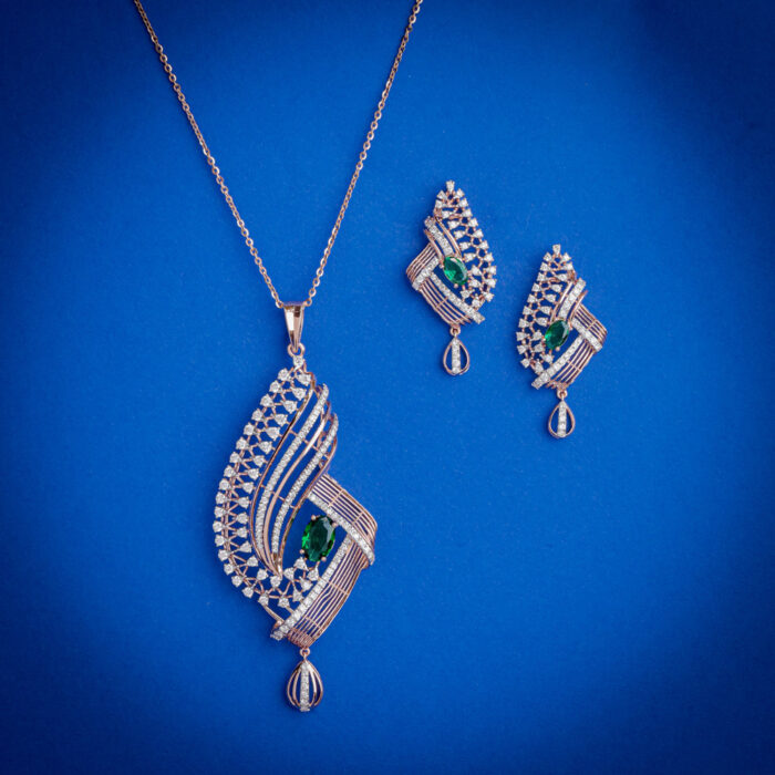 Designer diamond pendent set with green stone center and matching earrings in 14k gold