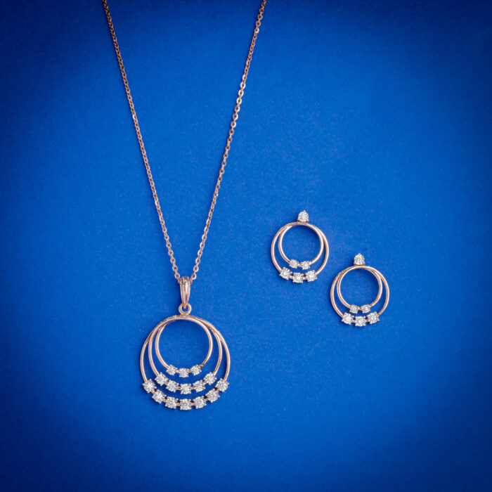 14kt gold diamond pendant set featuring a layered circular design with delicate diamond clusters and matching earrings.