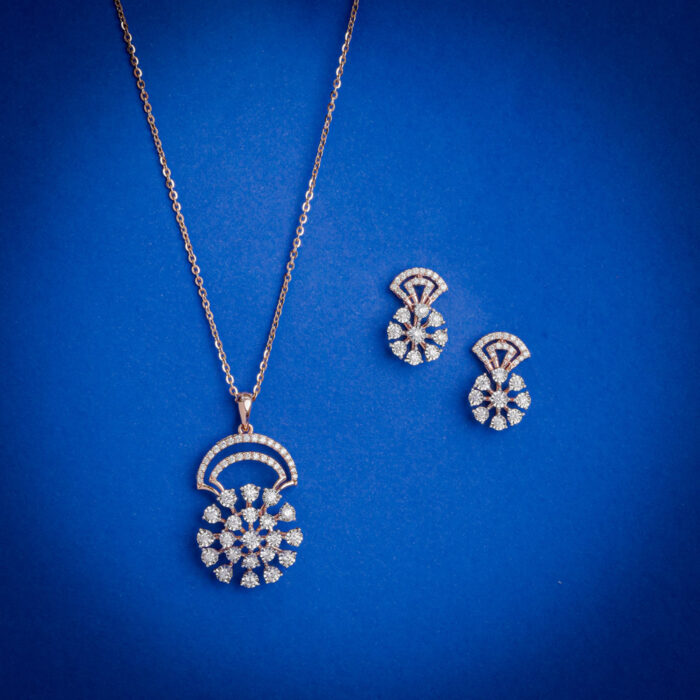 14kt gold diamond pendant set featuring a semi-circular top with a floral diamond cluster drop and matching earrings.